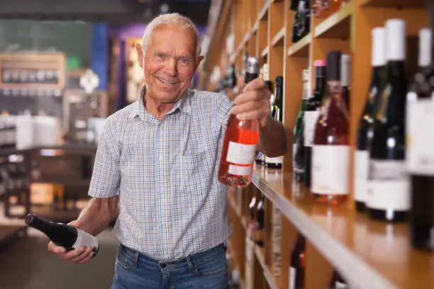 Glad man visiting winehouse in search of bottle of good wine