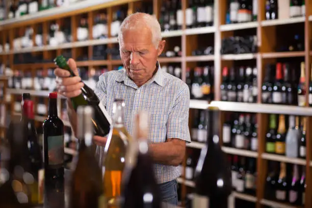 Fine man visiting winehouse in search of bottle of good wine