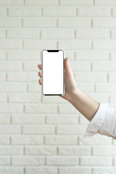 istock Woman holds and uses smartphone with a blank white screen for design. Mock up. 1243042328