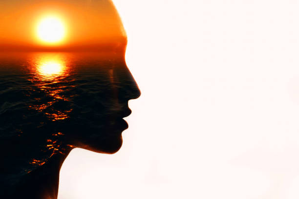 istock Woman head silhouette with sun inside with copy space. Multiple exposure image. 1243050474