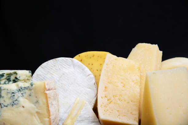 istock Closeup of different cheeses isolated on black background 1243055456