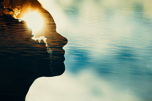 Woman silhouette with sun in head with copy space. Multiple exposure image.