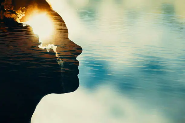 Photo of Woman silhouette with sun in head with copy space. Multiple exposure image.