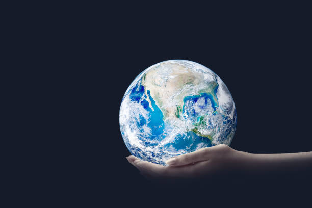 istock Ecology Concept : Hand holding blue planet earth in dark room. 1243063179