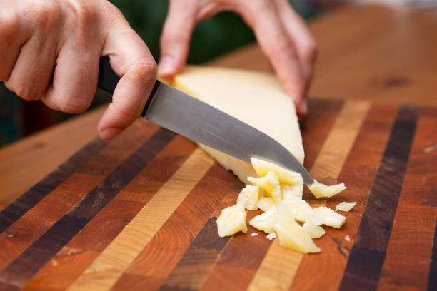 istock Female hands cutting parmesan on wooden board 1243065508