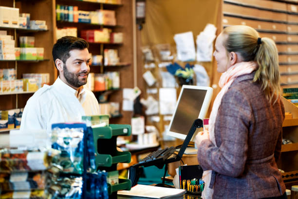 istock Pharmacist with customer at counter in store 1243068055