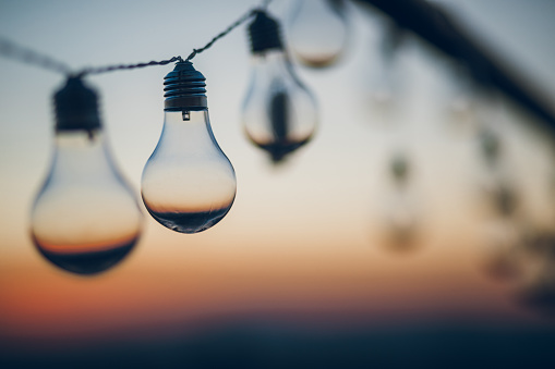 Close up picture of a string light bulbs at sunset on the rooftop.