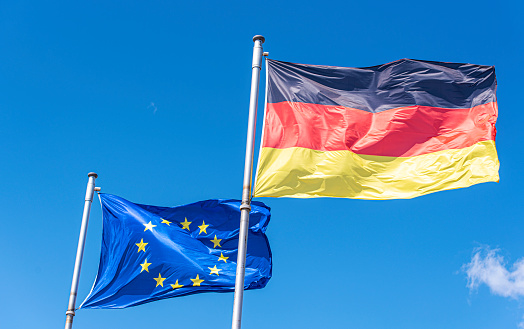 Germany and European Union Flags, EU flag, against blue sky