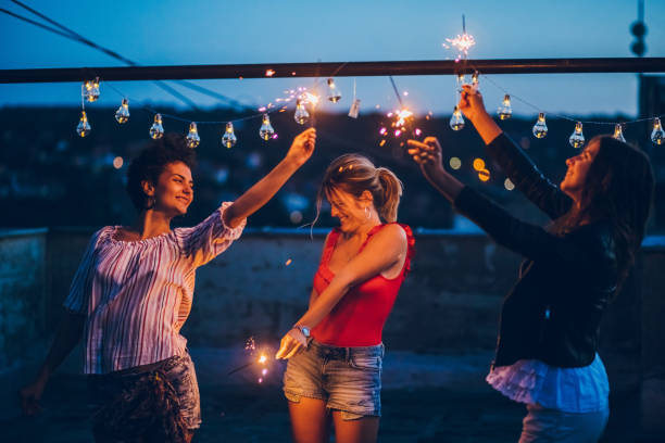 istock Rooftop party friends with sparklers 1243073991