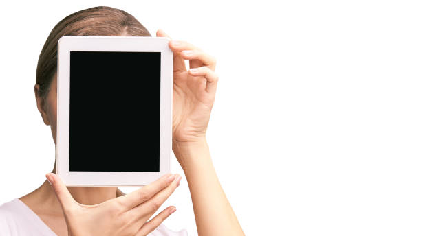 Girl holding computer pad. Mock up at tablet black screen. Face near laptop. Woman showing pc Girl holding computer pad. Mock up at tablet black screen. Face near laptop. Woman showing pc. person holding frame over face stock pictures, royalty-free photos & images