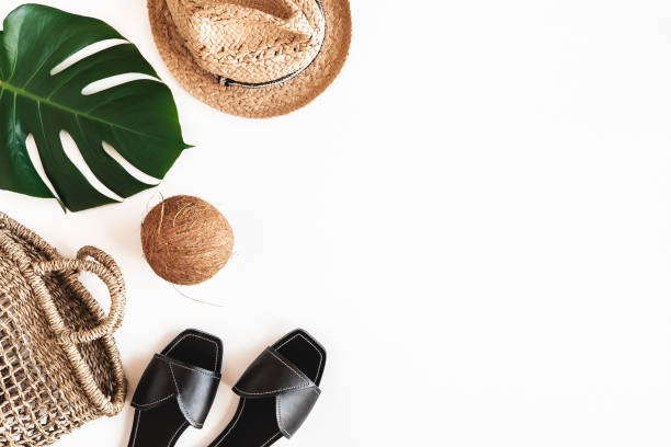 Summer clothes, tropical leaves on white background. Summer concept. Flat lay, top view, copy space
