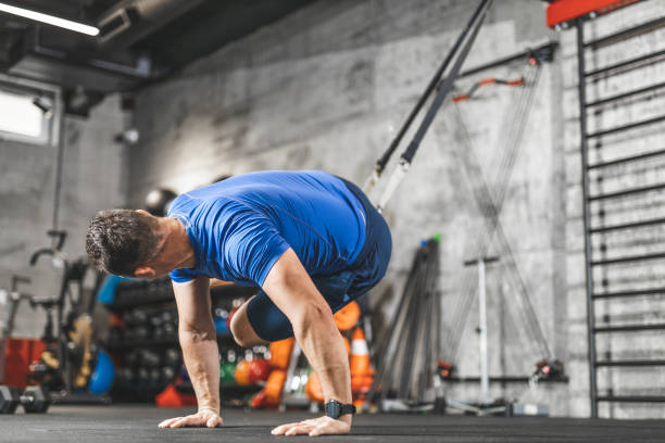 istock TRX training, Sports man doing abs exercise in a gym 1243079693