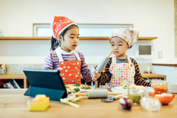 Children watching cooking instructions from the internet.