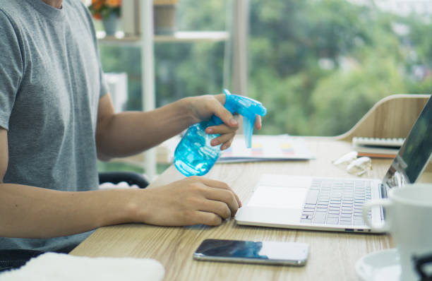 istock Close up young Asian man use Alcohol to clean computer laptop notebook when working on table at home and sitting in living room. corona virus, COVID-19 Pandemic new normal life at home Concept 1243112801