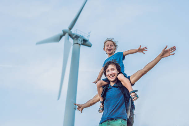 pai carregando filho nos ombros e acenando com os braços como um moinho de vento - alternative energy wind turbine environment energy - fotografias e filmes do acervo