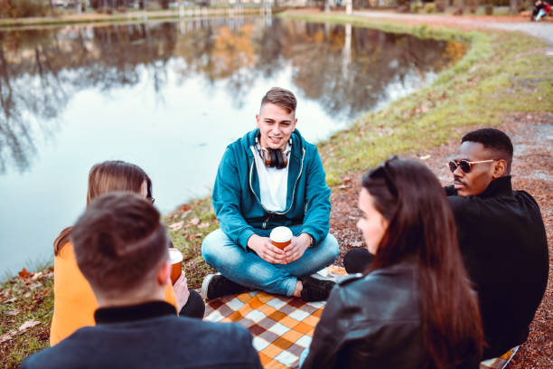 istock Friends Enjoying Coffee Picnic In Park 1243137071