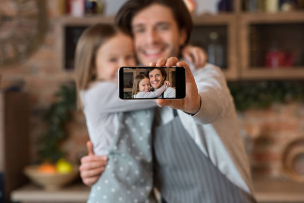 istock Happy dad and daughter taking selfie on smartphone while cooking at kitchen 1243138129