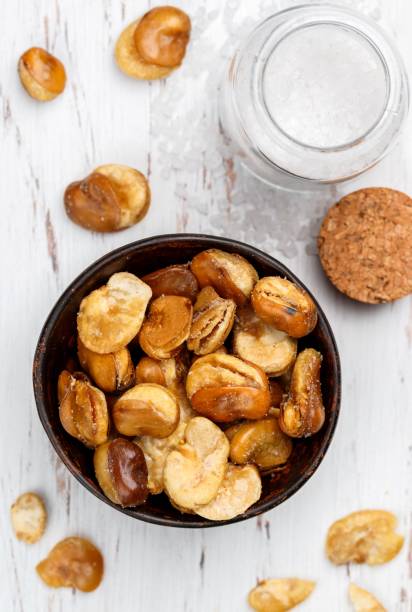 istock Crispy fried broad beans with salt in a bowl close-up on a table. Vicia faba. Selective focus 1243140925
