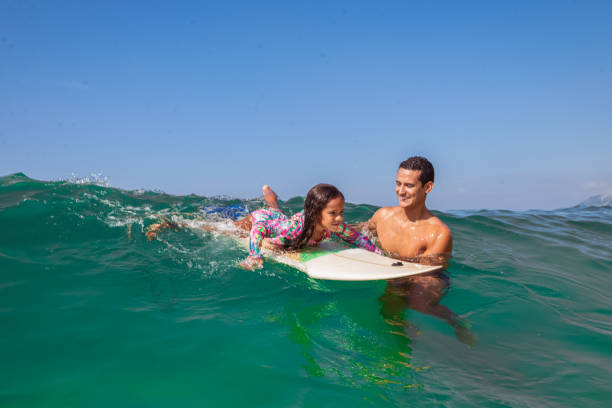 día de surf para padre e hija - surfing beach family father fotografías e imágenes de stock
