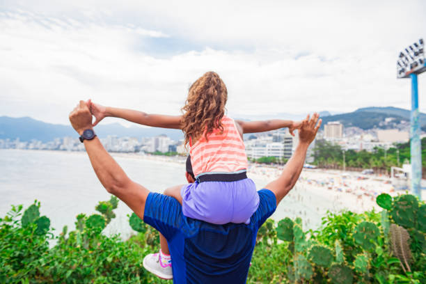 Father and daughter walking near beach Father holding his daughter on shoulders and walk family beach vacations travel stock pictures, royalty-free photos & images