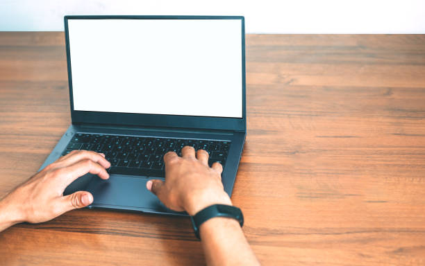 istock Hands on a laptop keyboard on the wooden background 1243150371