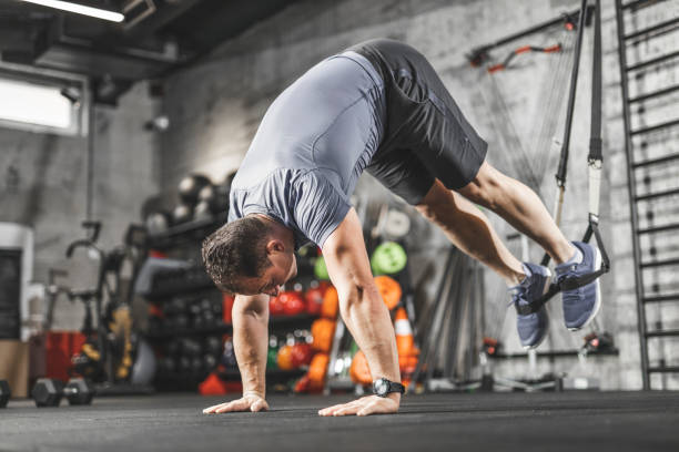 istock TRX training, Sports man doing abs exercise in a gym 1243150956
