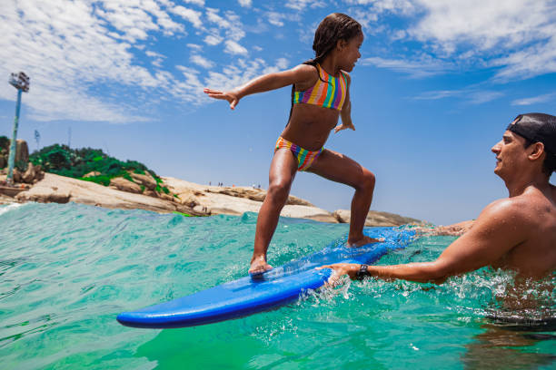 istock Little surfer rides on surfboard 1243156536