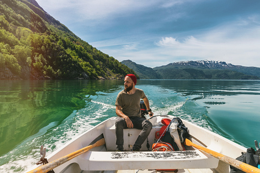 Fisherman on a small fishing boat: sailing in a fjord in Norway