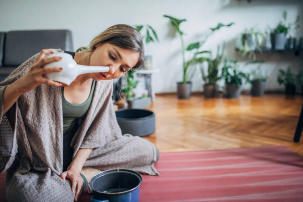istock Young woman using neti pot at home 1243165916