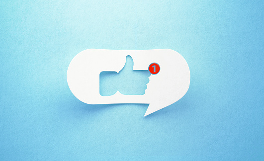 Thumbs up icon drawn white chat bubble on blue background. Red number one is written on the chat bubble. Horizontal composition with copy space. Social media concept.