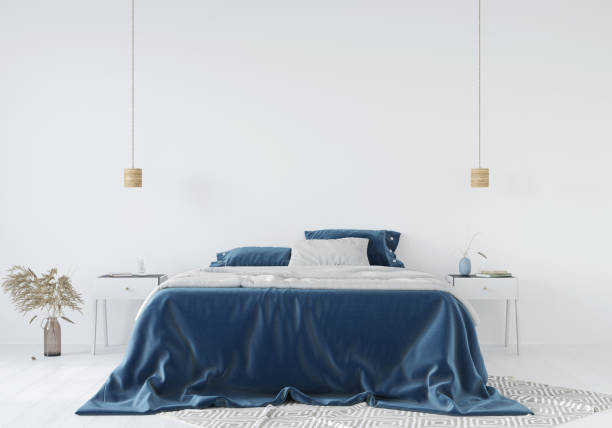istock Bedroom interior with a blue bedspread against a white wall background 1243187886