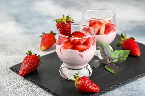 Dessert with fresh strawberry, ricotta, strawberry jam and basil on glasses. High quality photo