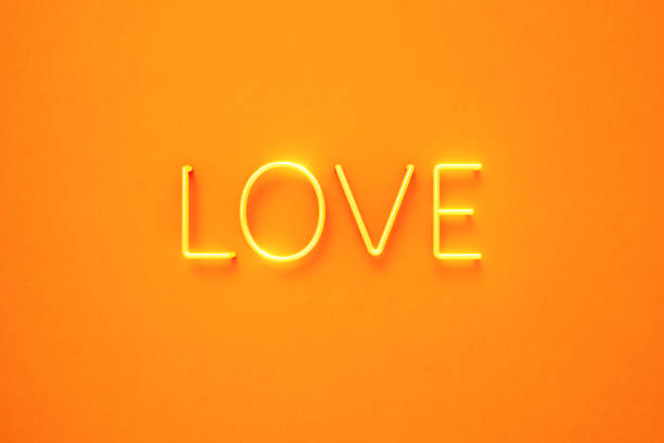 Love text written by yellow neon light on yellow background. Horizontal composition with copy space. Front view.