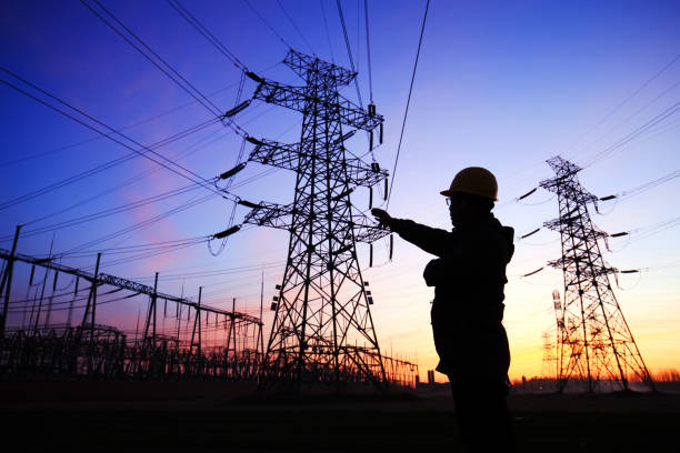 istock Electricity workers and pylon silhouette 1243195694