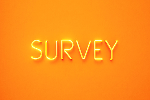 Survey text written by yellow neon light on yellow background. Horizontal composition with copy space. Front view. Survey concept.