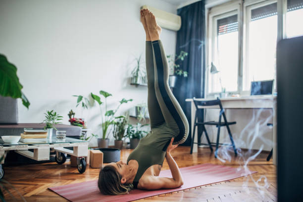 mujer acostada en la parte superior de la espalda y sosteniendo su espalda baja en equilibrio - aparatos para hacer ejercicio fotos fotografías e imágenes de stock