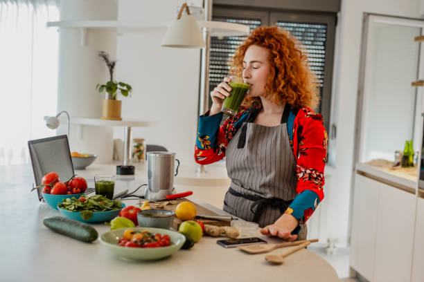 istock Young woman prepares a healthy drink 1243200871