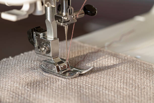 istock Closeup of sewing machine working part with beige fabric 1243209424