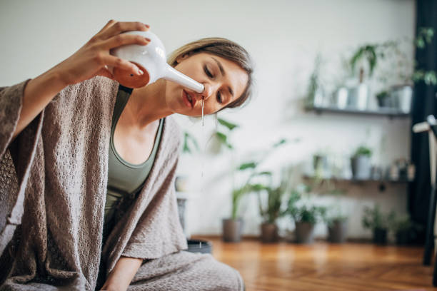 istock Beautiful woman using neti pot at home 1243221947