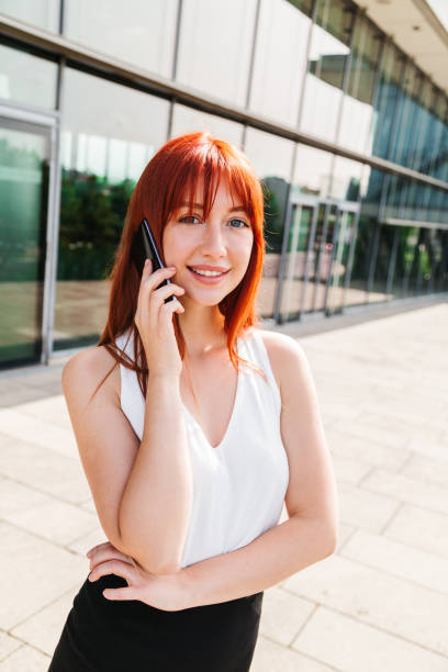 istock Young woman talking on mobile phone near building 1243244929