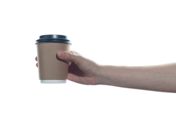 istock Woman hand holding a brown coffee paper cup isolated on white background. 1243245521