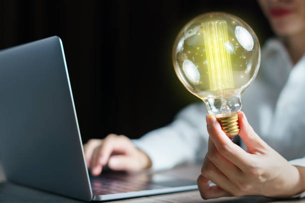 istock Woman using computer laptop and hand holding light bulb. idea concept. 1243246360