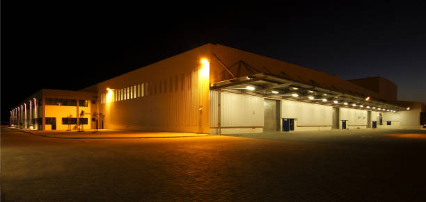 istock External wide angle view of modern warehouse at night 1243246387