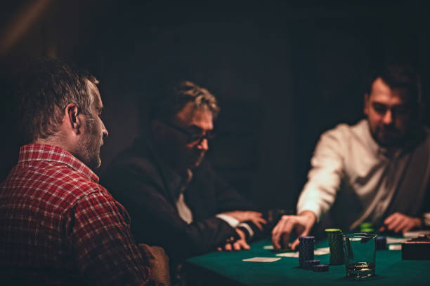 istock Men playing poker in dark room at night 1243247189