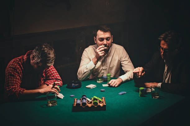 istock Men playing poker in dark room at night 1243247349