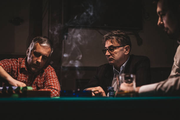 istock Men playing poker in dark room at night 1243247377