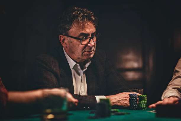 istock Senior man playing poker in dark room at night 1243250795