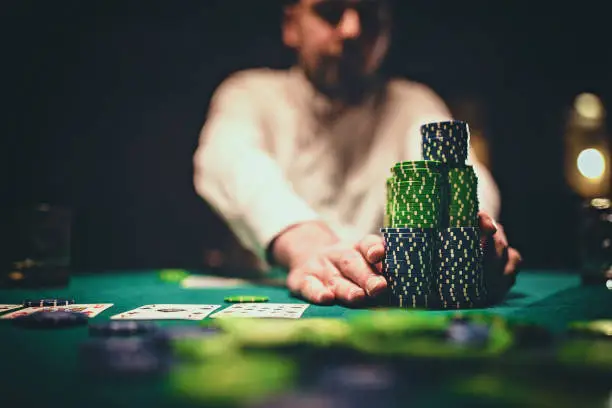 One man, gentlemen playing poker in dark room at night.