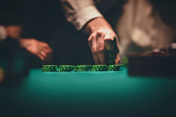 Gentlemen holding gambling chips in casino Gentlemen playing poker at night, man is holding gambling chips in his hand. poker card game photos stock pictures, royalty-free photos & images