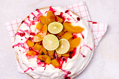 Pavlova Meringue Cake Decorated With Peach Berry Jam and Lime Tasty Homemade Summer Dessert Horizontal Top View